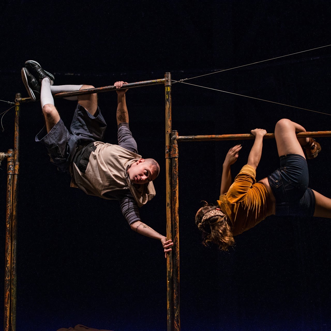 Elenco en un ejercicio de teatro físico sobre estructuras metálicas en la obra La luz que causa una bala — Colectivo Pies Hinchados
